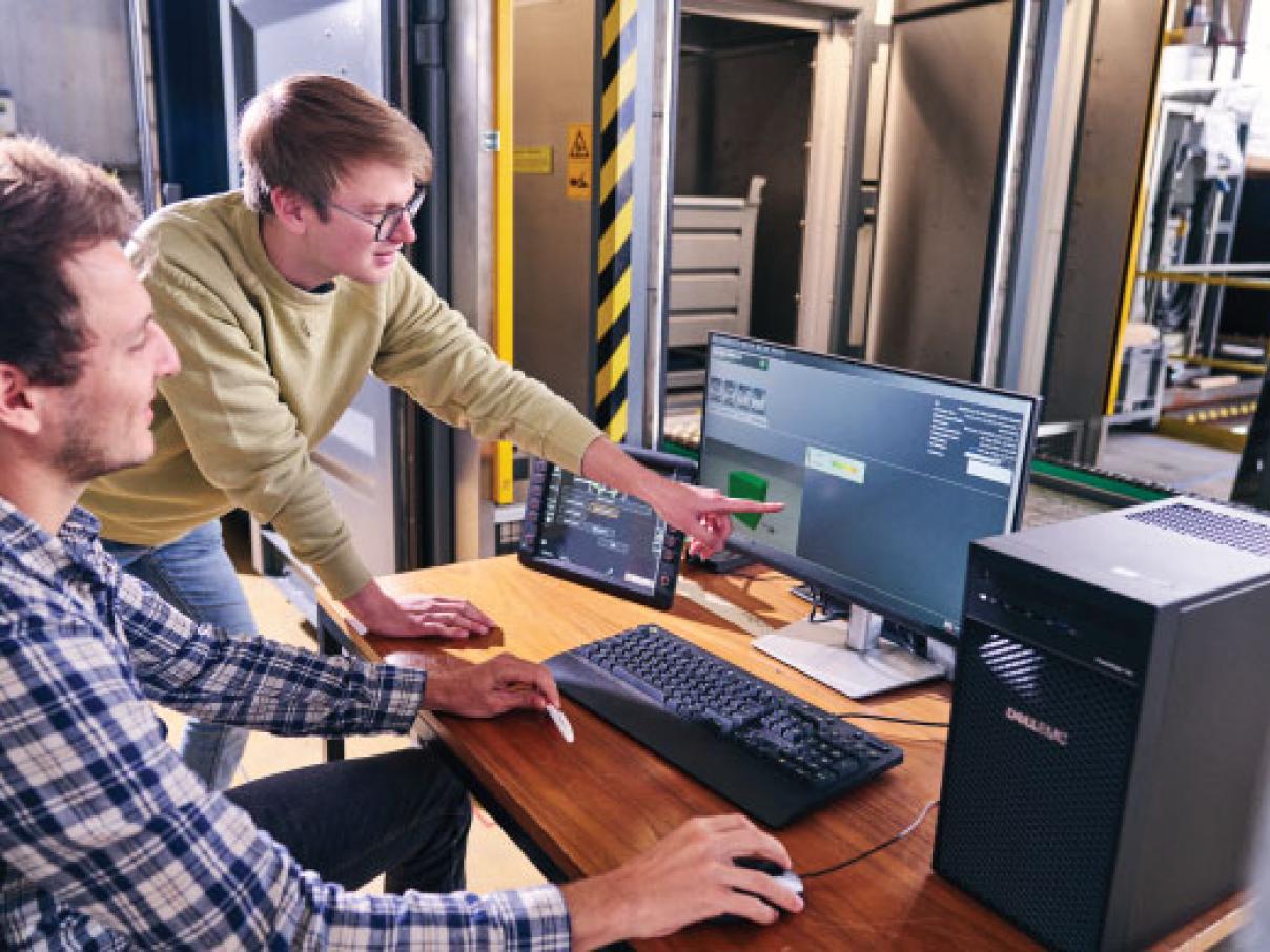 2 characterization experts working with E.R.N.I.E. behind computer